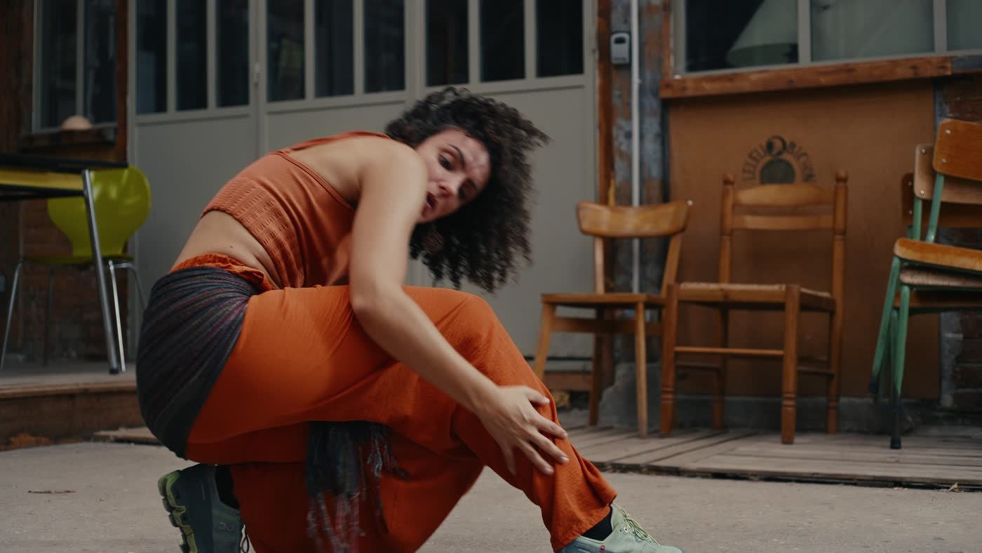 Caroline pliée en deux, en orange